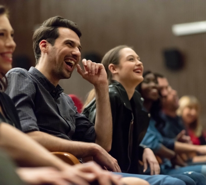 People laughing in an audience.