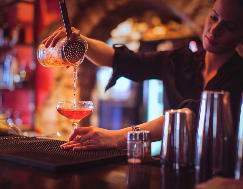 A bartender pouring a cocktail at The Cruise Room in Denver, Colorado.