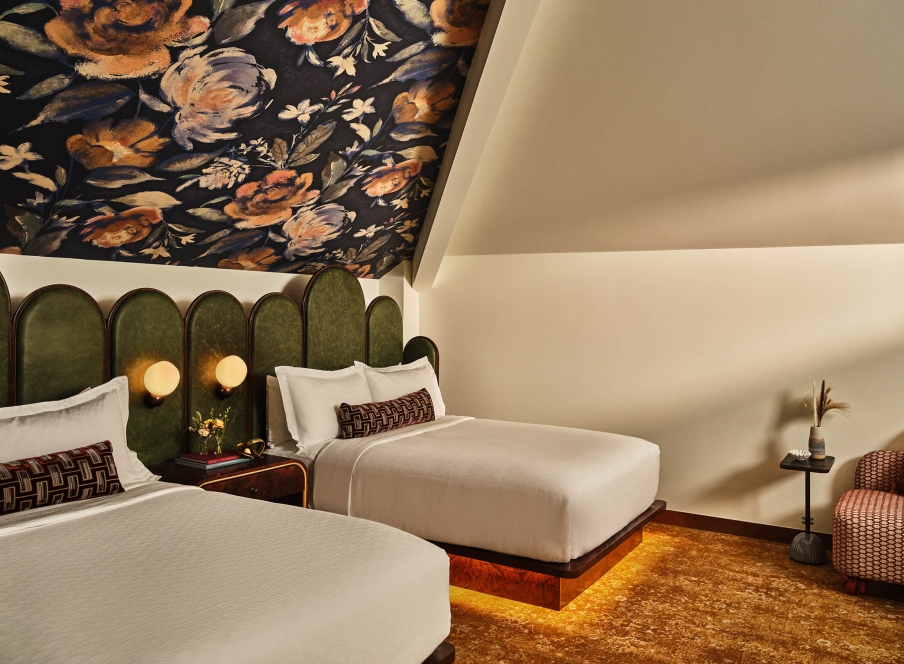 Two queen beds and seating area in the Deluxe Loft Guest Room at the Crawford Hotel in Denver, Colorado.