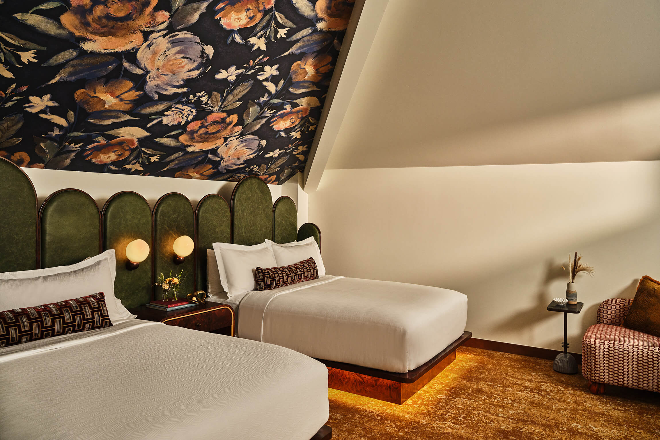 Two queen beds and seating area in the Deluxe Loft Guest Room at the Crawford Hotel in Denver, Colorado.