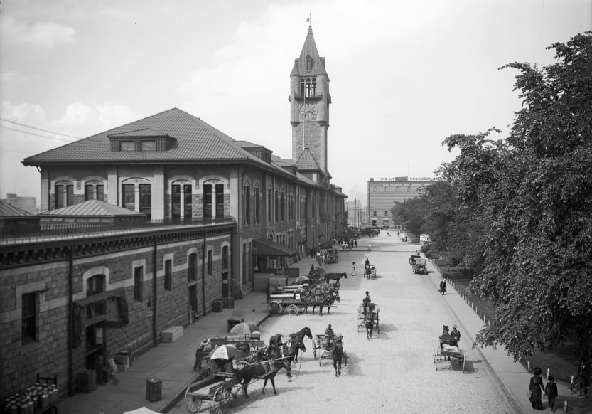 A historical photo of Denver, Colorado. There are multiple horse and buggies.