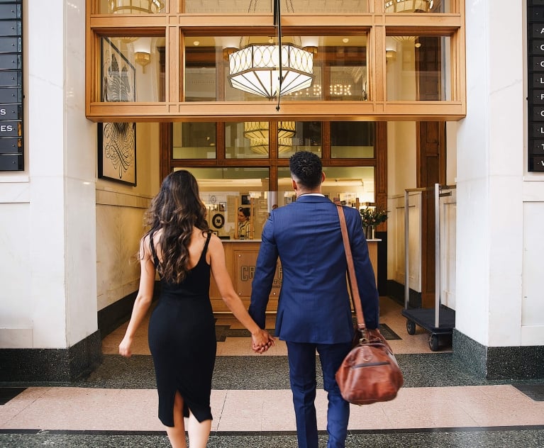 A couple walking up to the main desk at the Crawford Hotel in Denver, Colorado.
