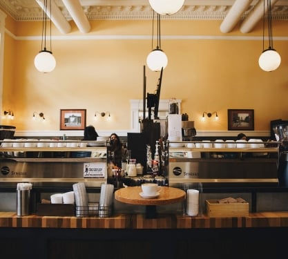 Pigtrain Coffee Co. in Denver, Colorado. A latte is ready to go on the bar.