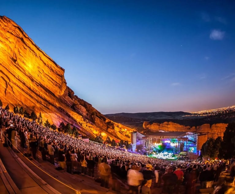 A concert taking place at dusk at Red Rocks Amphitheatre in Colorado.