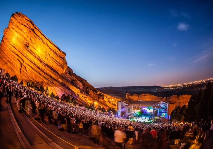 A concert taking place at dusk at Red Rocks Amphitheatre in Colorado.