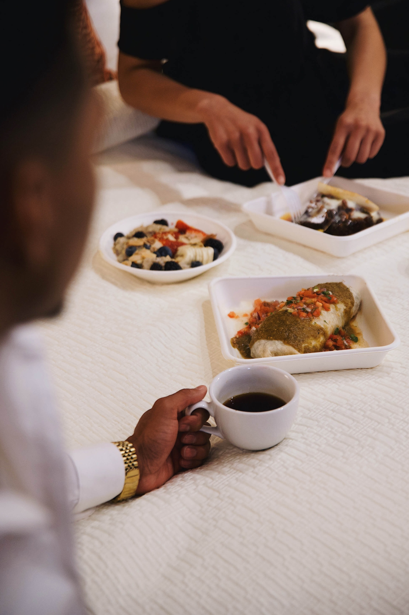 Two hotel guests enjoying a room service meal and coffee.