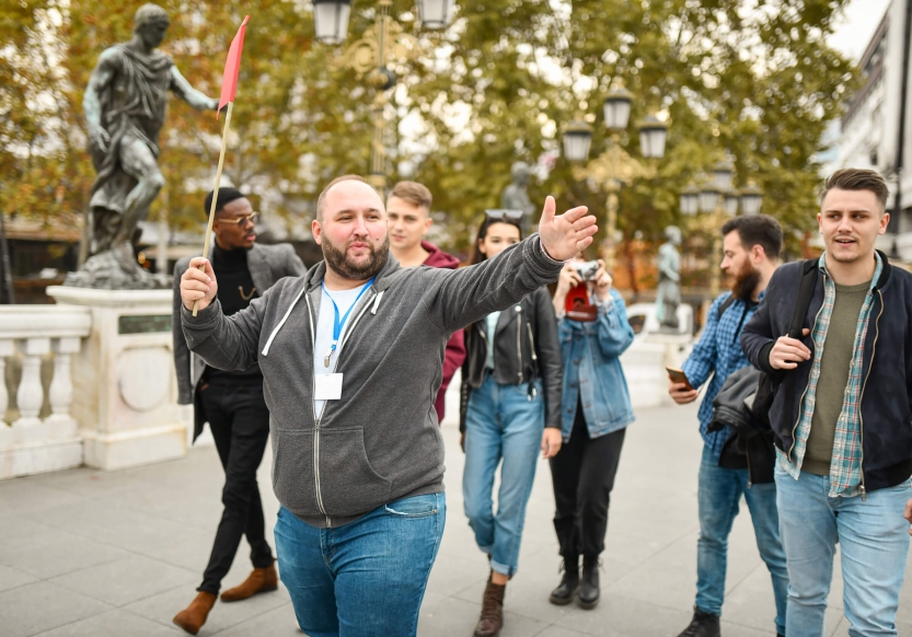 A guide gives a walking tour in a city to a group of tourists.