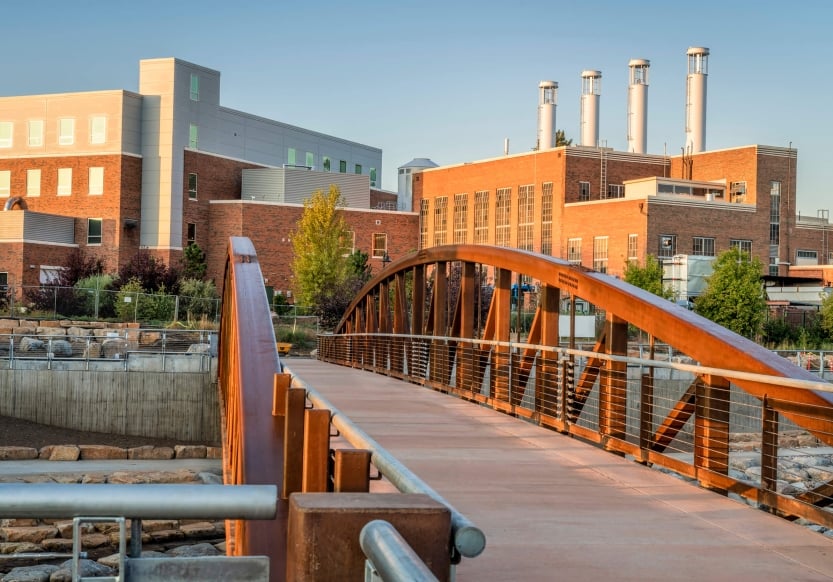 A bridge with a brick building in the background.