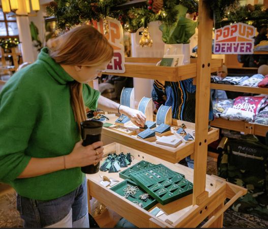 A woman shops for artisan jewelry in a market.